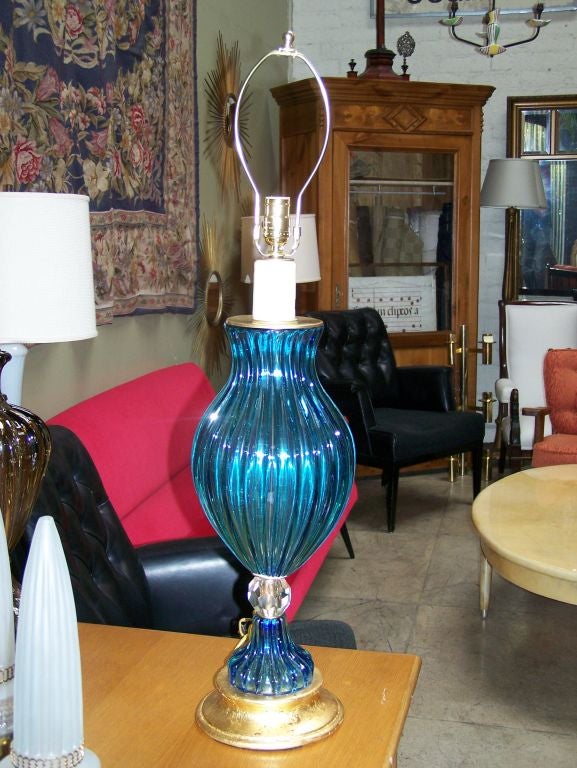 Lampe de table en verre bleu de Murano, base en bois doré. Nouvellement recâblé. Une vraie bougie de pointe.
Dimension : H 24