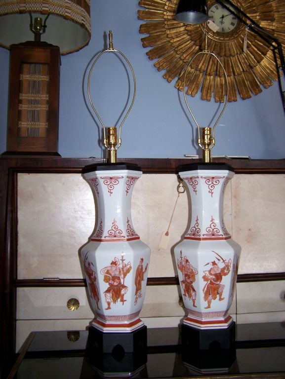 Élégante paire de lampes de table de style asiatique peintes à la main sur de la porcelaine, avec base et plateau en bois ébénisé. Nouvellement recâblé.