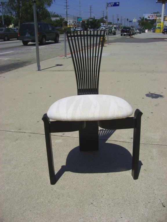 This rare set of Totem dining chairs by Norwegian designer, Torstein Nilsen, includes two captain's chairs and four side chairs. These sculptural dining chairs are rendered in lacquered wood and feature their original upholstery.