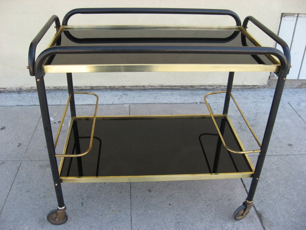 Very useful cart and bar in brass and lacquered iron with black opaline glass tops.