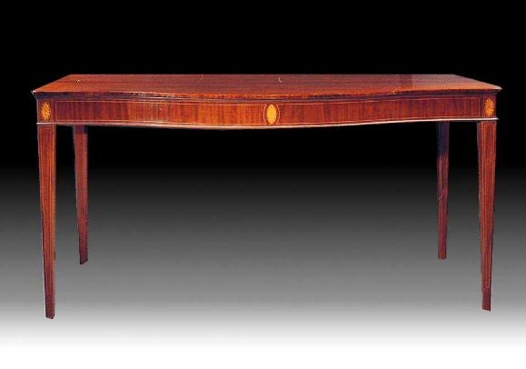 # P047 - George III serpentine side table executed in beautifully figured mahogany and retaining a superb color and rich patination. Inspired by the neoclassical designs of George Hepplewhite, see his “Cabinet Makers.