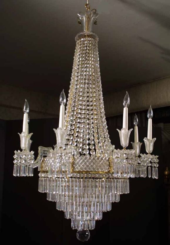 Regency gilt metal and cut glass eight light chandelier having a graceful waterfall design and beautiful proportions. Surmounted by a stepped and fan cut corona above draped chains of graduated octagonal, faceted buttons. The eight faceted angular
