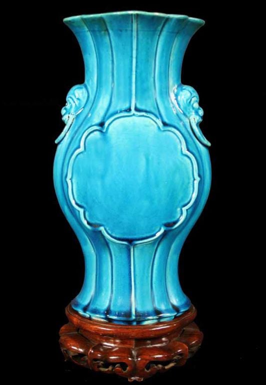 Chinese porcelain fluted vase with a drip turquoise glaze. The baluster form with a flare neck flanked by a pair of lion head molded handles and centering a scalloped round panel.<br />
Chinese, 18th century<br />
<br />
See similar examples of