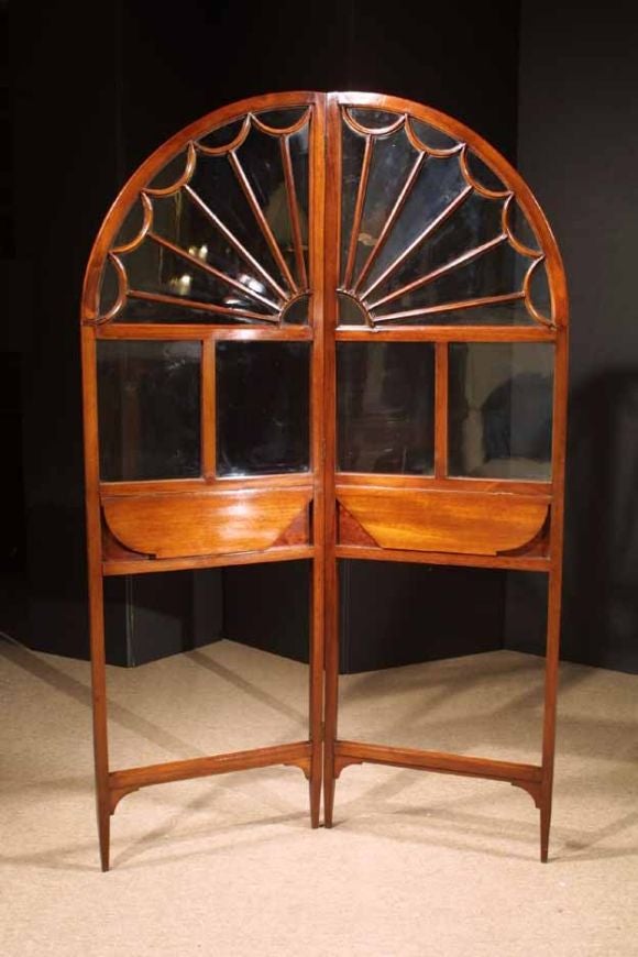 # N060 - Georgian style two fold Mahogany screen inspired by Palladian windows. The mahogany panels with fold down shelves and decorative glass mullioned half round segments shapes above.
English, Circa 1900

See similiar examples of screens,