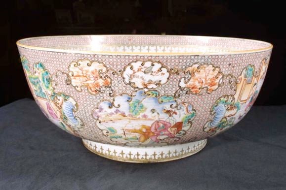 # H023 - Large Chinese Export famille rose porcelain punch bowl beautifully decorated with a finely patterned and spearhead border inside and out. Note the exterior with figural vignettes in rococo shaped reserves. Each with classical landscape