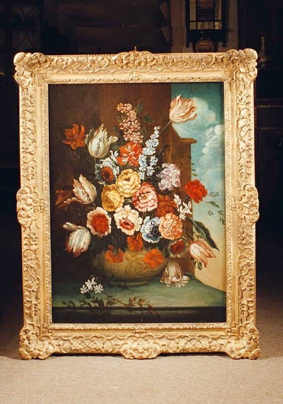 # H107 - Attractive early 19th century Italian floral painting depicting tulips, roses and other flowers in full bloom nicely arranged in a classical vase and resting on a shelf. The background is of a dark architectural detail and cloudy sky.