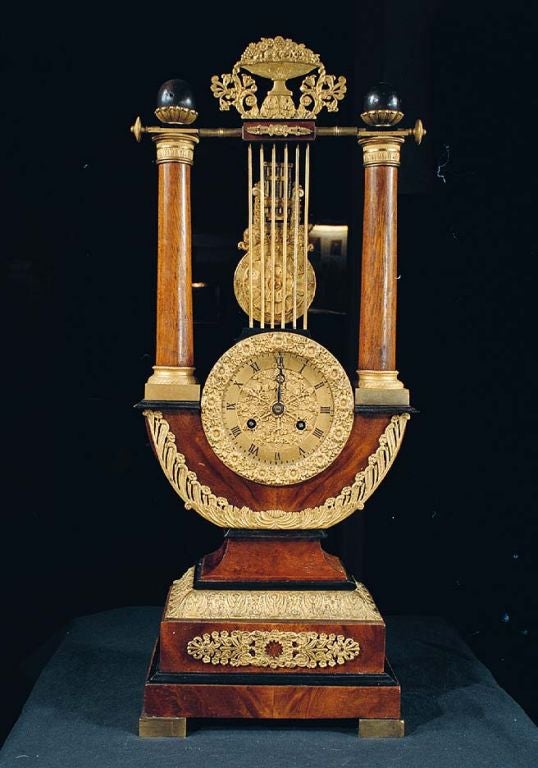 # F316 - Charles X fine quality, large size, gilt bronze mounted amboyna wood table clock. This decorative form is a rare survivor of the early 19th century. The top is surmounted by a finely cast urn shaped mount with scrolling foliage which is