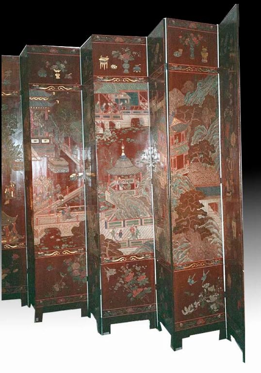 Rare Chinese 12 fold 18th century Coromandel screen.  This piece is quite unusual with its warm brownish-red background.  The lacquer is finely carved with courtly figures in a garden setting enjoying leisure activities, such as music, painting, and