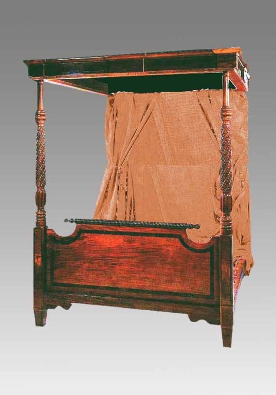 A handsome Regency mahogany four poster bed, having a molded and string inlaid cornice. The round turned front posts with spiral twist are finely carved with stylized foliage. The shaped footboard is inlaid with crossbanding and a ring turned crest