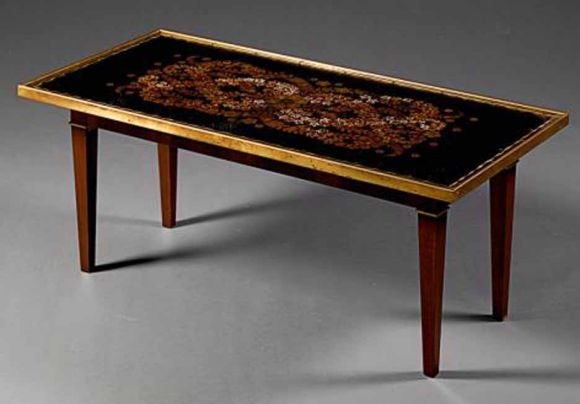 Art Deco eglomise coffee table in the manner of Jules LeLue and bearing a small inlaid plaque to top of one leg bearing signature Jules LeLue. The verre eglomise rectangular top decorated with a spray of flowers and banded in gold. All Raised on a