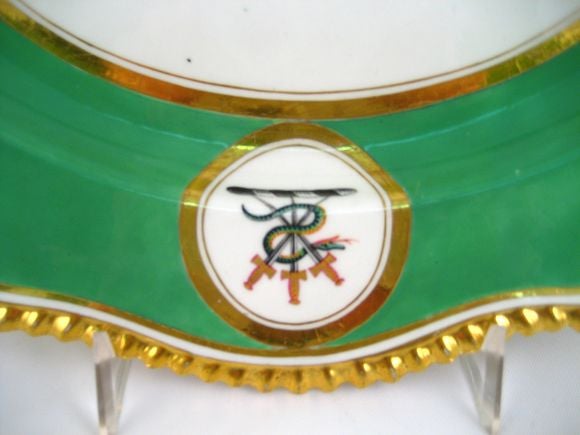 A finely formed and painted Flight, Barr, & Barr porcelain serving platter. Crested in two locations, the armorial depicts a serpent woven around three swords. Surrounding is a deep green ground with  beautiful gilding and a 