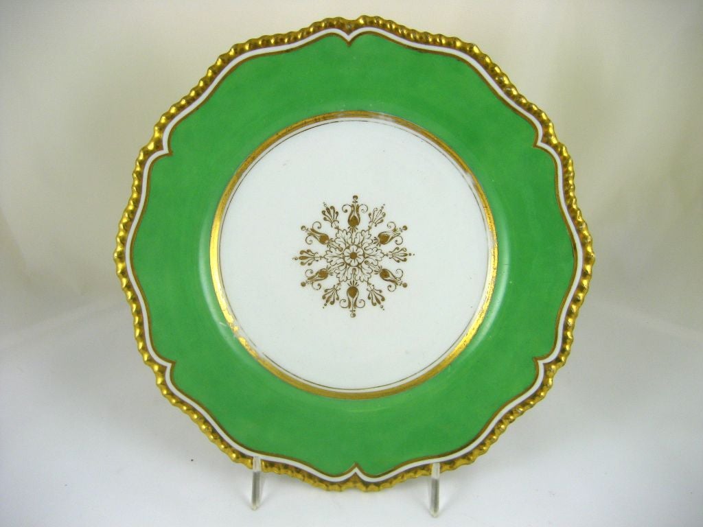 A refined pair of porcelain luncheon plates from the Flight Barr & Barr Porcelain works. Decorated in the Regency Neo-classical taste, with a gilt sunburst design in the central panels, reserved by a apple-green ground and gilt border on a gadrooned