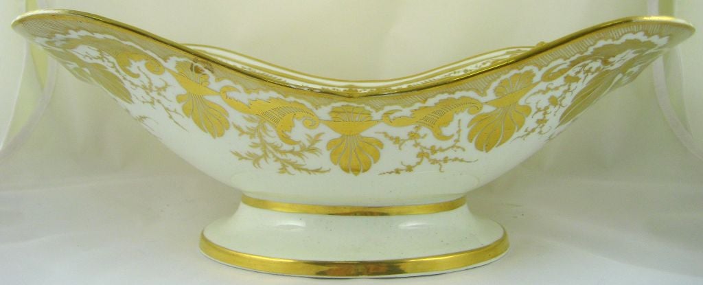 A Derby porcelain Comport center-piece, with molded lion-mask designs in each corner, and fluidly-formed handles on each end. <br />
<br />
The curvaceous forms of the porcelain are complemented by the Neo-classical gilded silhouettes, which form