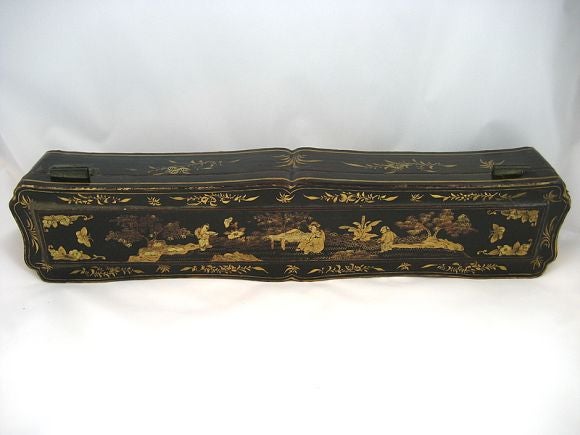 This delightfully quaint and delicate piece is an unusual example of the lacquering process, designed to hold a small woodwind musical instrument. The box has a black-lacquered shell, and a metal spring-hinge, opening to reveal a velvet and sewn
