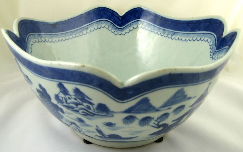 A beautifully-formed Chinese export porcelain salad bowl, with a serpentine shape to the top square edge, which transitions to a round bowl at the base, slightly raised on a foot-rim. The painting is idealized scenes of the Chinese countryside, with
