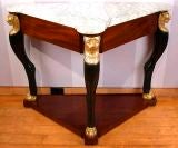 An Empire Parcel-Gilt, Ebonized and Mahogany Triangular Table