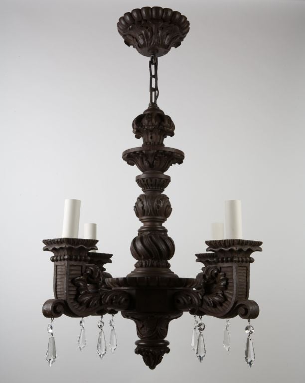 AHL2961<br />
A solid and crisply carved dark wooden four light chandelier. Having foliate carvings overall and accented by faceted prism pendants.  From a Hudson River estate in Athens, NY.<br />
<br />
Current height: 57 1/2