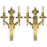 A pair of two-arm gilt sconces with rams heads and berried swags