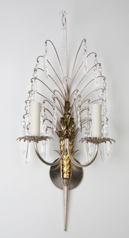 A pair of two arm silver and brass crystal sconces
