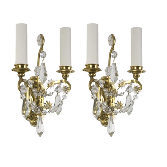 A pair of aged brass and crystal Caldwell sconces