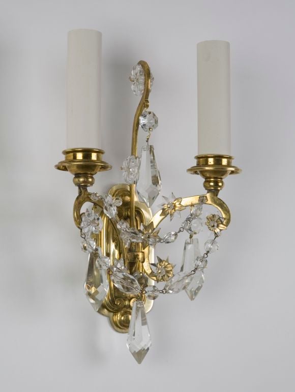 IS2286<br />
A pair of double light sconces of age-mellowed cast brass, dressed with clear prisms, stars, and beaded chains. Signed by the New York Maker E. F. Caldwell. From a Grosse Pointe Farms, MI estate.  <br />
<br />
Backplate: 4 3/4