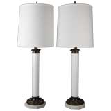 A pair of white glass and bronze column lamps