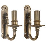 A pair of single arm bronze sconces