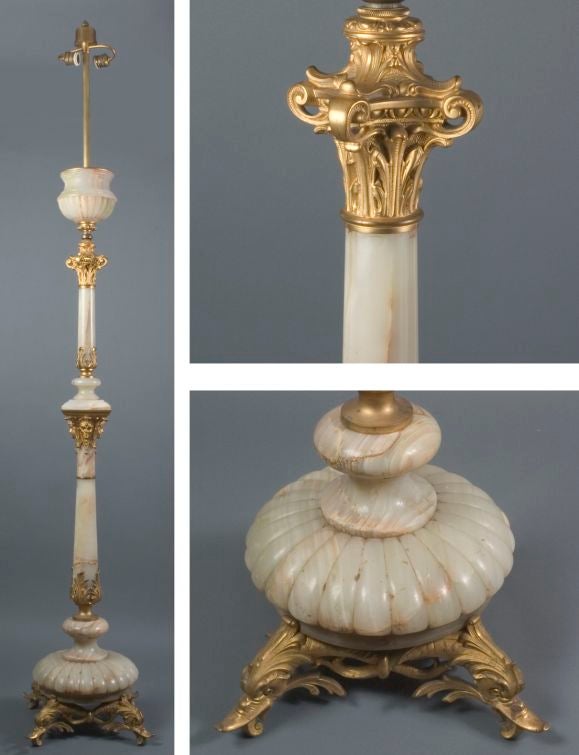 AFL1577

A finely carved alabaster and gilt bronze floor lamp detailed with dolphin heads, foliage, masks and a Corinthian capital. Originally fluid-fueled, later converted to electricity. With some small chipping to one of the body segments. Shade