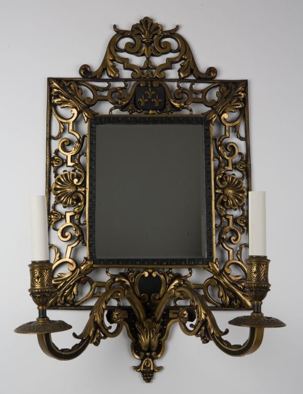 A pair of large bronze mirrorback sconces