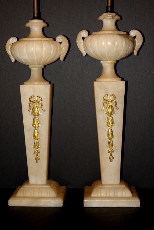 Pair of circa 1920s French carved alabaster table lamps with gilt bronze details.

Measurements:
Height of body 20