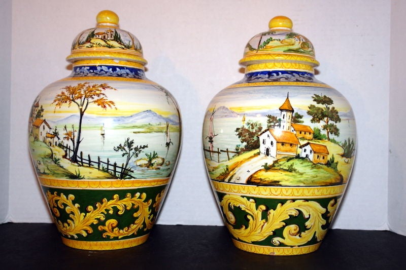 Pair of circa 1920's Italian hand painted porcelain lidded vases with.

Measurements:
Height: 13