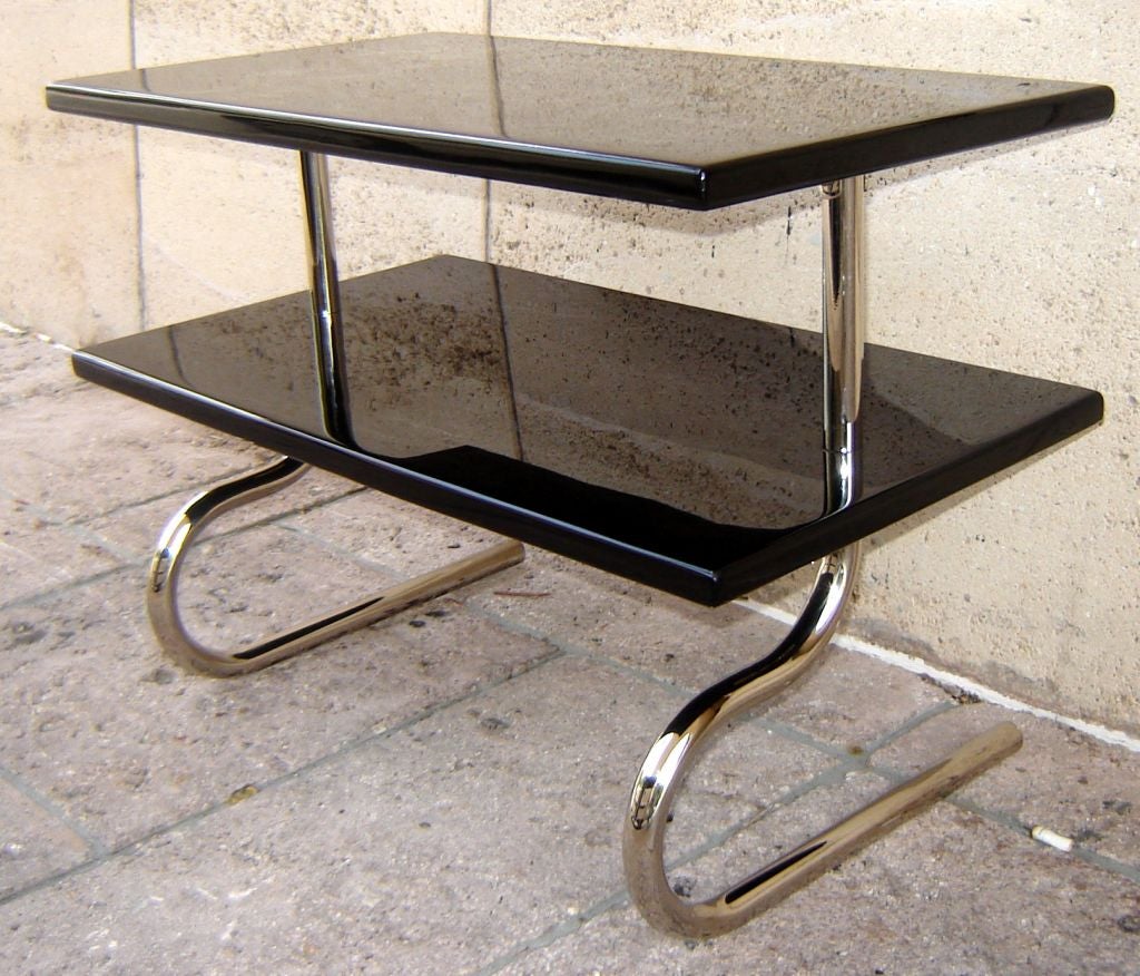 A rare two level occasional American art deco table designed by Gilbert Rohde (1886-1958) for the Troy Sunshade Company in the 1930s. This table, in high gloss black lacquer and bright chrome, will stand out in any interior. The table measures