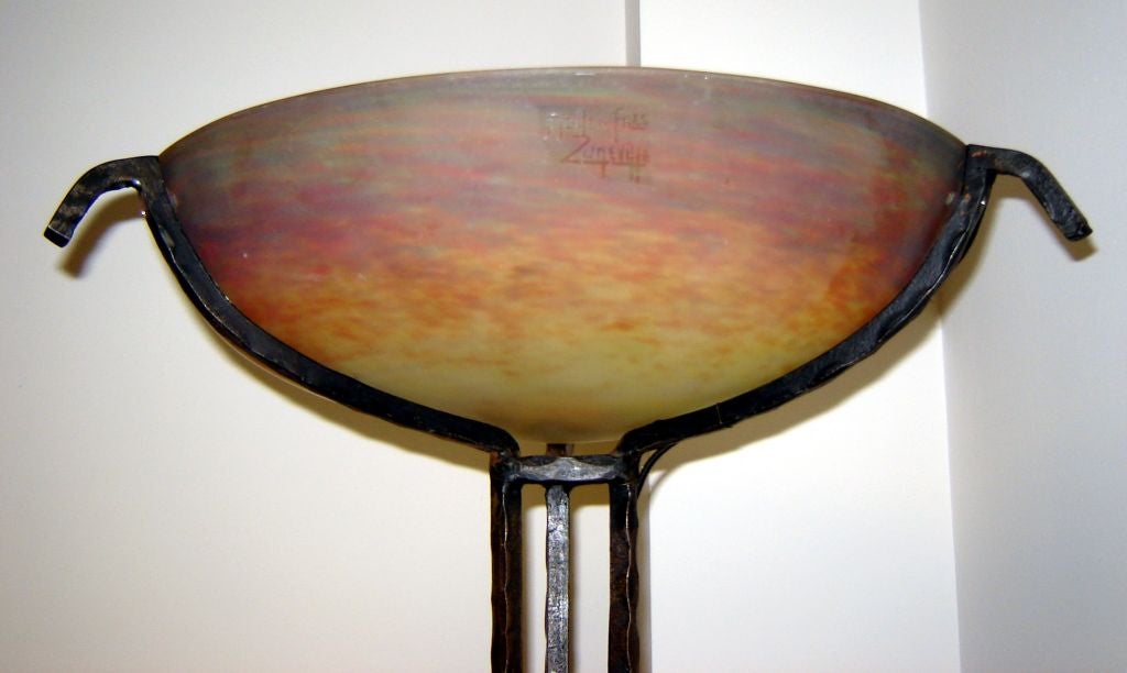 This art deco torchiere was made in the 1920’s by the French wrought iron master Edgar Brandt (1880 – 1960). The 17 ½” diameter shade is of internally decorated pate de verre glass by Muller Freres (1919 – 1936). The tall 72” torchiere would make a