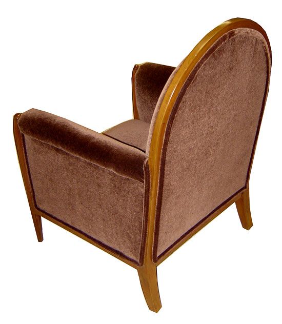 This pair of French art deco club chairs date from the 1930’s. The carved front legs extend up to support the arms and the round back is surrounded by a matching wood crest. The chairs have been reupholstered in warm brown mohair. They measure 28 ½”