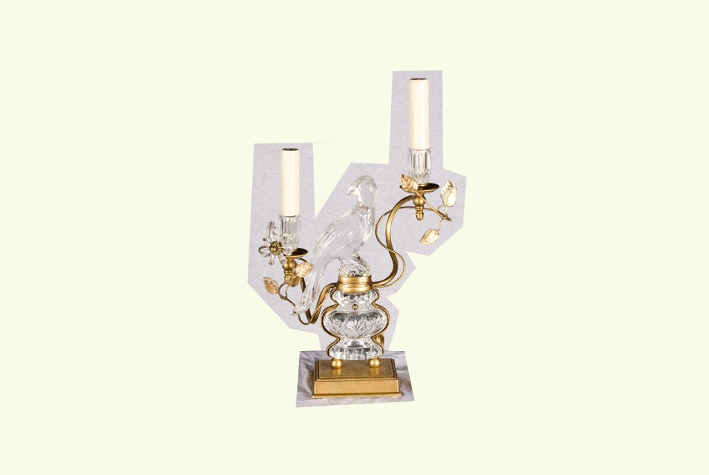 This extraordinary pair of crystal table lamps in the famous parrot design is finished on both sides so that they can be placed on center tables or in front of a mirror without concern about showing the back of the lamp. The delightfully curved gilt