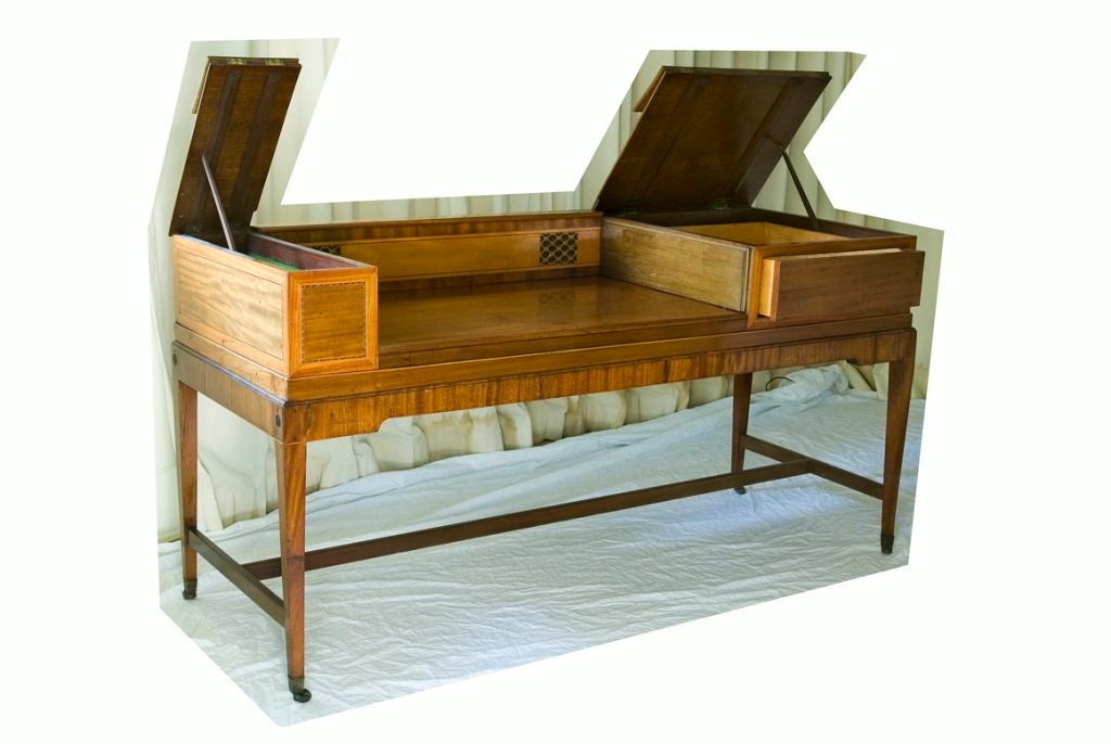 This light fruitwood desk started its life as a piano-forte in the early 19th Century.  At some point later in that century it was turned into a writing desk with two flap lids on each side for storage.  The clean lines of the desk allow it to fit