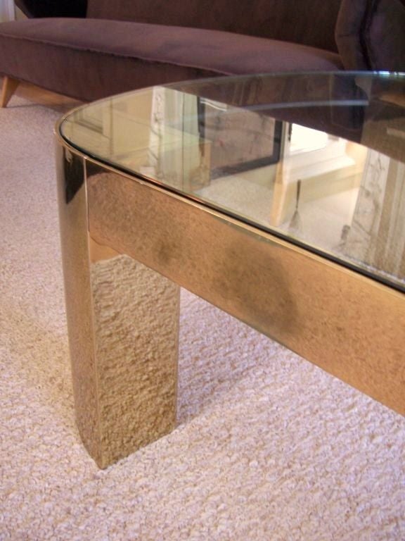 Oval coffee table in brass with glass top.