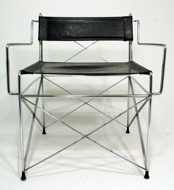 An incredibly well-engineered and comfortable pair of black vinyl directors chairs with multiple bends in solid chrome steel tubing and intricate construction down to the edges of the feet.