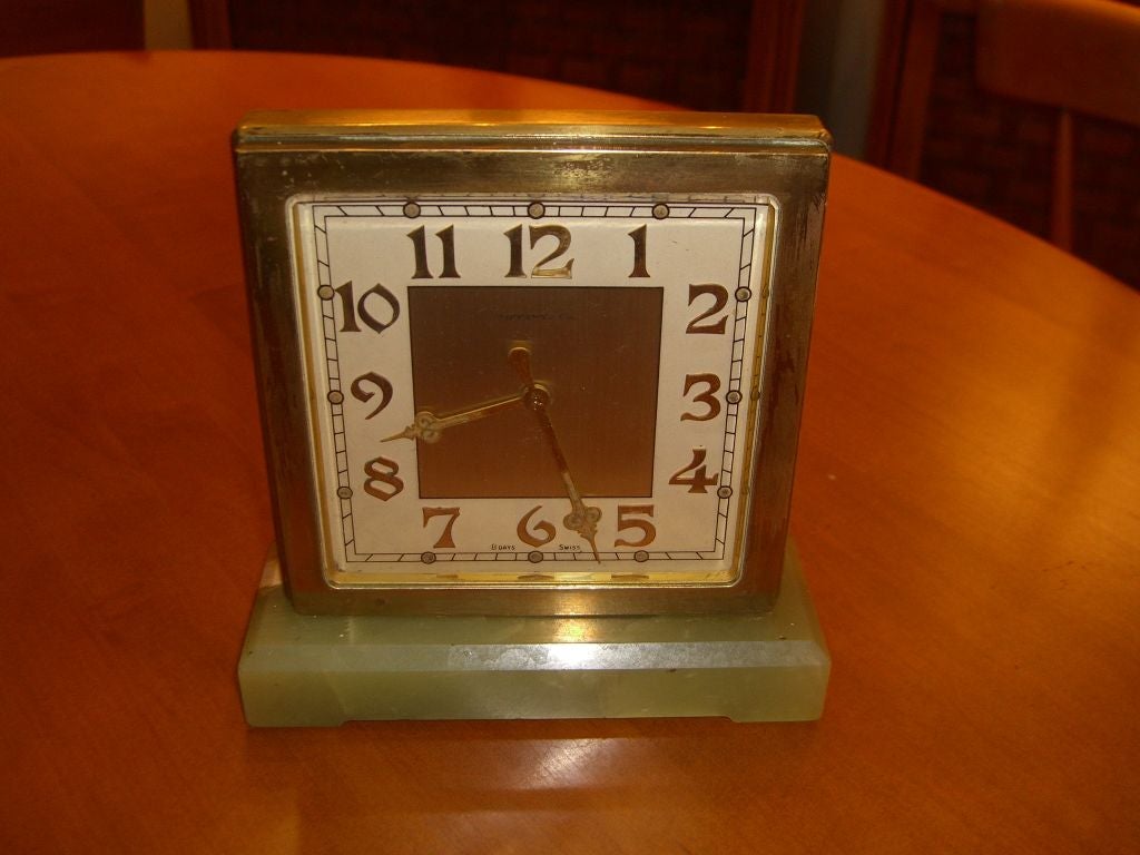 A rare and unusual Art Deco 2 sided partner's desk clock retailed by Tiffany & Co. The clock is running nicely and keeps accurate time. It is an 8 day clock. The base is made of a green colored Onyx and the case is Brass. The Case has scratches and