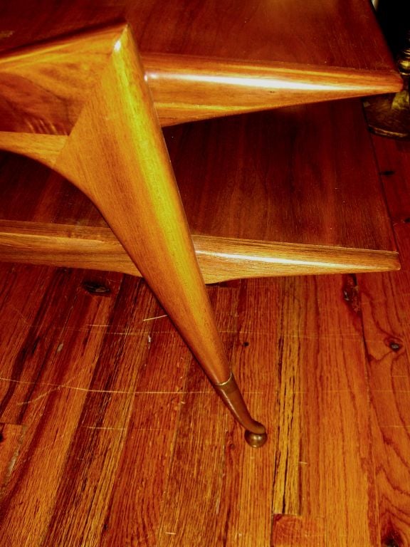 A nice looking Grasshopper shaped table with brass clad feet ending in a ball. Based on the foot design we are attributing this table to Ico Parisi. Two tiered with the lower tier longer than the top. The table has been restored, but there are some