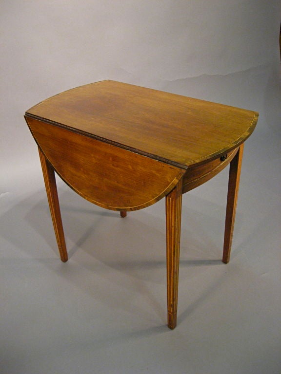 A George III Period Oval Pembroke Table in Mahogany, with Boxwood line inlay on the legs, and the table with a border of Rosewood cross-banding and string inlay. <br />
<br />
The Table with a single sliding drawer on the frieze, and resting on