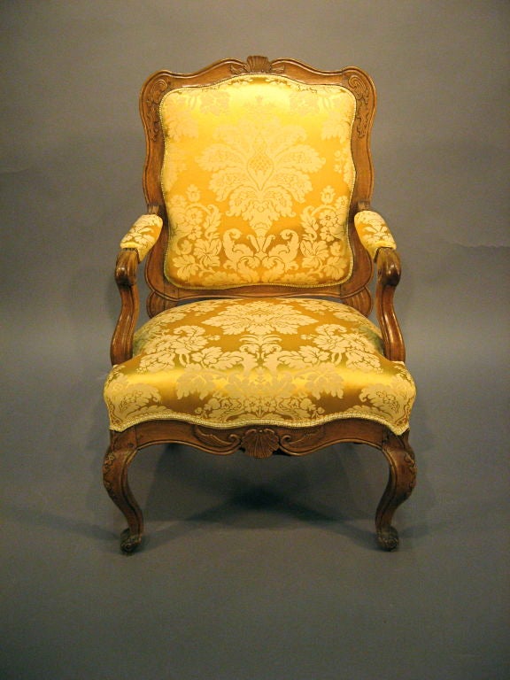 A Fine Regence period Fauteuil in Walnut, dating from c. 1730 and Italian in Origin. <br />
<br />
The piece features a curvaceous form with thick Walnut construction, with silk upholstery on the seat, back, & arm-rests.