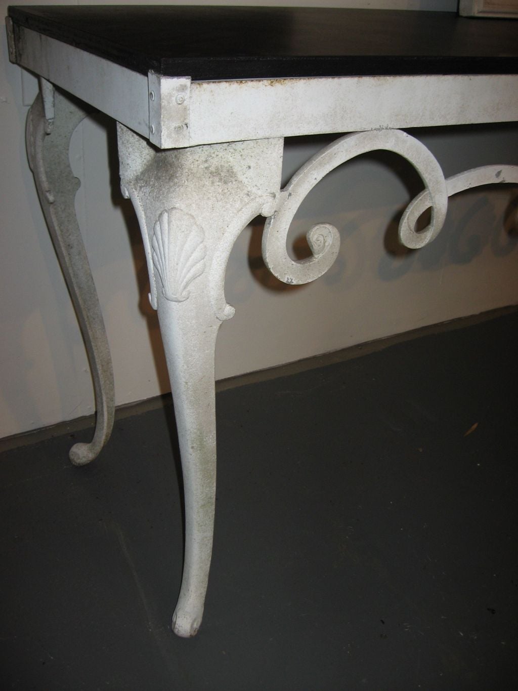 Cast aluminum console table with a wood top.