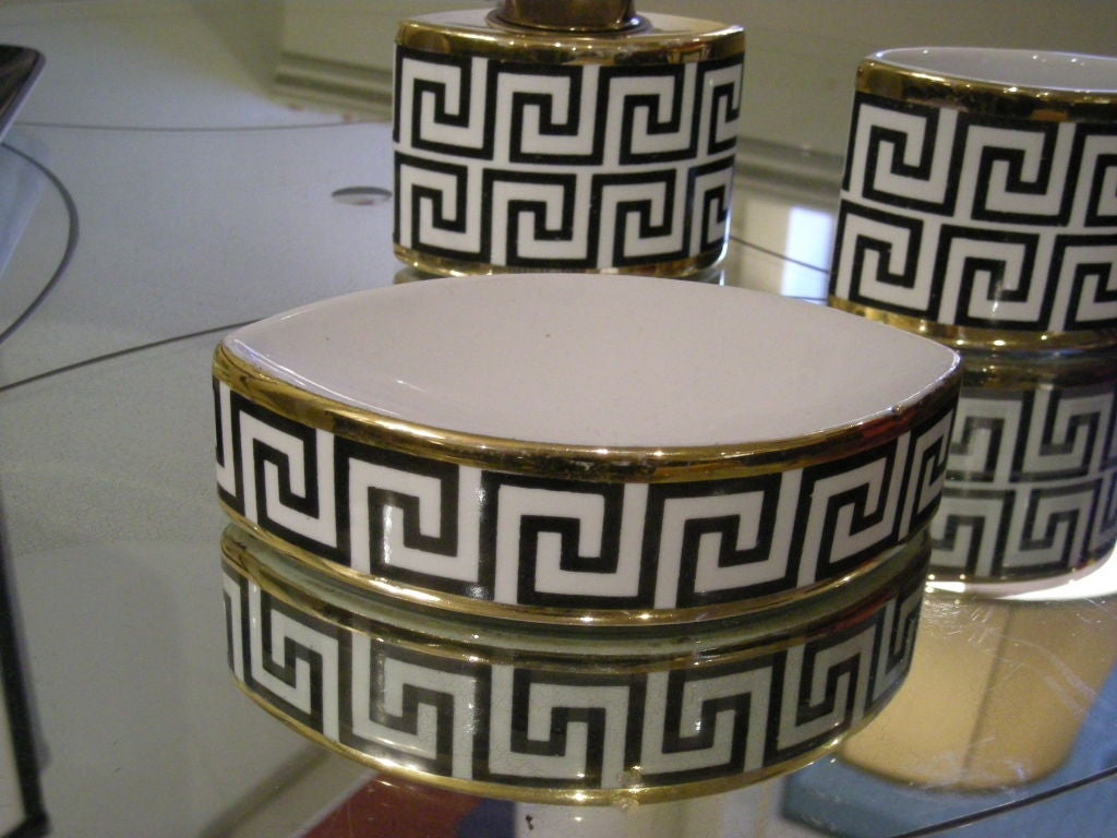 3 piece Fornasetti black and white and parcel gilt Greek key decorated porcelain lighter, cigarette holder and ash tray.