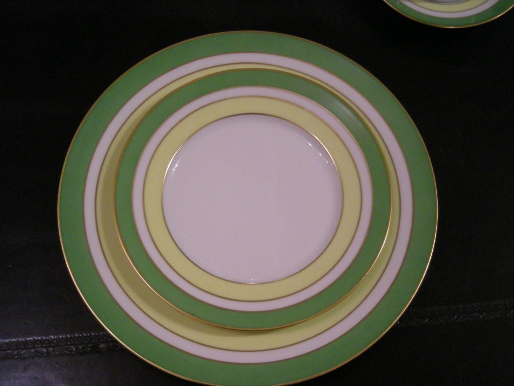 Royal Limoges porcelain 5 piece dinner service for 10, decorated with apple green and yellow bands, with gilded edges, comprising 10 of each: Dinner plates, salad plates, bread plates, tea/coffee cups, saucers.