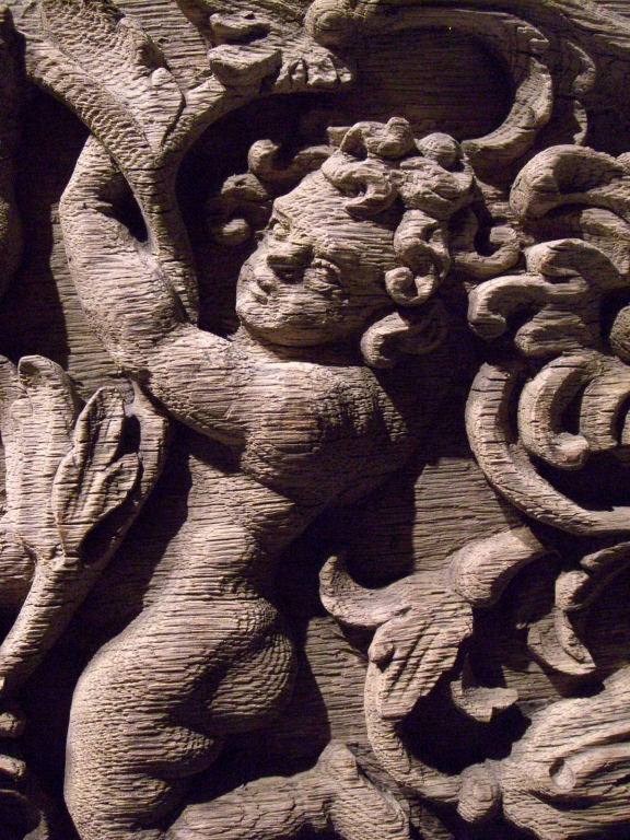 A carved oak panel with foliage and putti