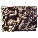 A carved English oak panel with foliage and putti