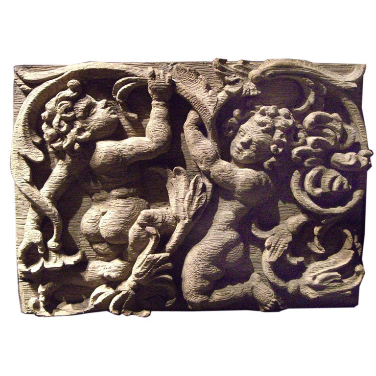 A carved English oak panel with foliage and putti For Sale