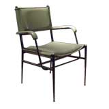 A green skai armchair by Jacques Adnet