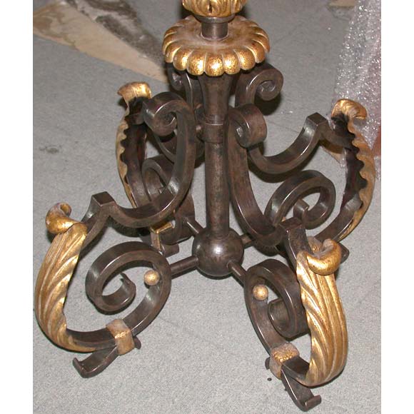 A tall floor lamp by Gilbert Poillerat on a gilt wrought iron scrolled acanthus leaf footing, an acanthus leaf bottom and top crowned twisted column stand and 5 scrolled branches ending in 5 candle held lights.  The last photo is of the lamp prior